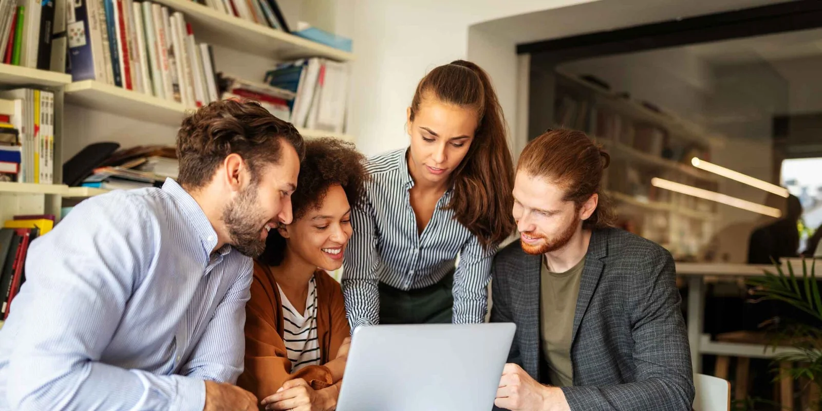 equipo de trabajo reunido frente a una laptop